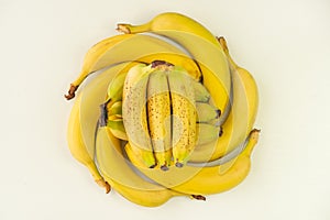 Bananas folded in the shape of a circle lie on a white background of the table. top view, above view