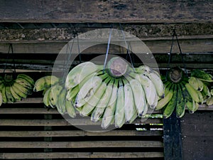 Bananas hanging with raffia rope in a busy market