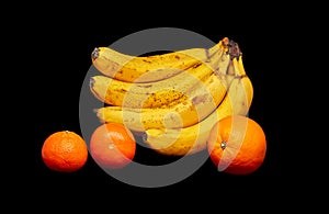 bananas orange and two tangerines on a black background