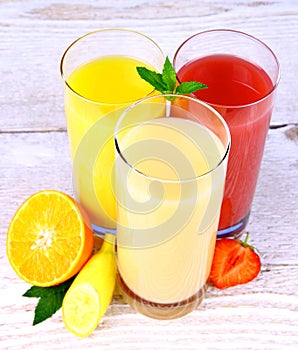 Bananas, strawberry and oranges slice, juice in glass