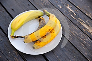 bananas in various different states of ripeness on a plate