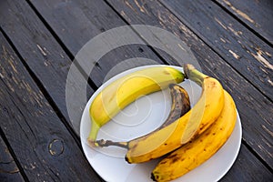 bananas in various different states of ripeness on a plate
