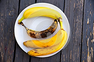 bananas in various different states of ripeness on a plate