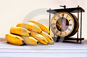 Bananas and vintage clock on a warm summer day