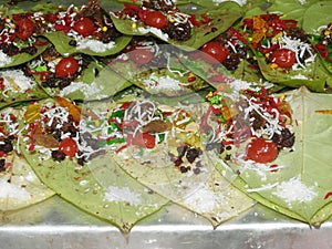 Banarasi paan or betel leaf garnished with betel nut and all indian colorful banarasi ingredients for sale photo