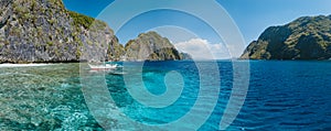 Banca boat moored near limestone rocks of Matinloc island, highlights of hopping trip Tour C. Most beautiful place at Marine