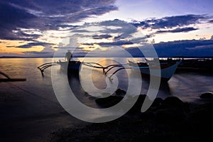 Banca boat at sunset on the beach photo