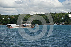 Banca fishing boats moored off Dauis, Panglao, Bohol, Philippines with Tagbilaran in the Background