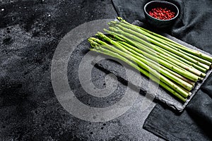 Banches of fresh green asparagus. Black background. Top view. Copy space