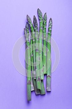 Banches of fresh green asparagus on lilac background