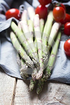 Banches of fresh green asparagus on wooden background