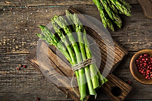 Banches of fresh green asparagus on wooden background