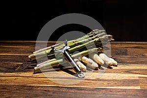 banches of fresh white and green asparagus on wooden background black textspace top view