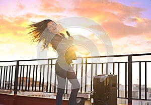 Band girl singing karaoke outdoor at roof terrace