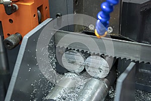 The band saw machine cutting raw metals rods photo