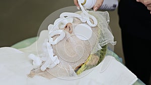 A bandage mask using gauze fabric. Applying foam to the face.