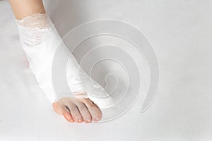 Bandaged big toe with foot on white background. Concept of fracture of the foot and thumb, close-up, copy space