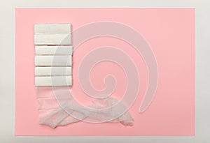 Bandages in rolls on a pink background, top view. The concept of first aid for injuries, sprains, dislocations and fractures