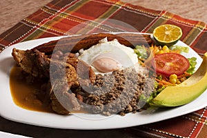 Bandeja paisa traditional dish in medellin with pork rice egg banana lemon tomato avocado and red beans