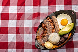 Bandeja paisa, typical dish at the AntioqueÃ±a region of Colombia. It consists of chicharrÃ³n fried pork belly, black pudding,