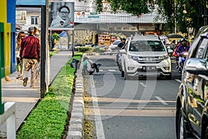 Road cleaners work on the side of the Alun-Alun street, Bandung.