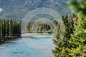 Banff Pedestrian Bridge and Bow River trail in summer sunny day. Banff National Park, Canadian Rockies