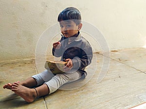 Beautiful Indian Kid Eating Tender Coconut by Hand photo