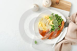 Bangers and mash. Grilled sausages with mash potato and green pea on white plate on light background. Traditional dish of Great