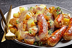 Bangers and roasted potatoes on a plate