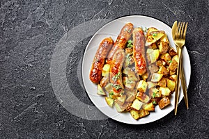 Bangers and roasted potatoes on a plate