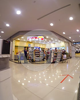 Blurry photo of a convenience shop inside a supermarket building with few customers during the