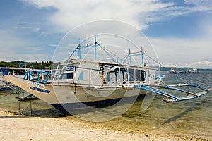 A bangka, the traditional filipino boat, moored on the shore. Tulubhan beach. Boracay Island. Western Visayas. Philippines