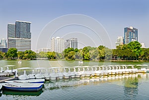 Bangkok cityscape and paddle boat in a lake of Lumphini public park. Public park in metropolitan