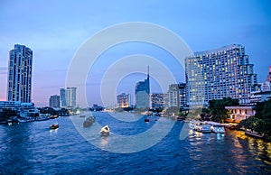 Bangkok cityscape with river and boat at night time