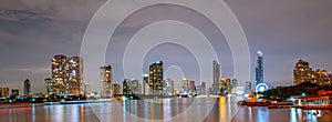 Bangkok cityscape of river front modern building in Thailand. Beautiful night scene of river,downtown building, sky and clouds.