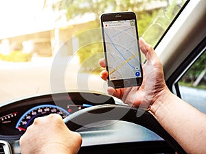 BANGKOK, THAILAND - 24 APRIL 2017: Close up of man holding  smartphone in car, Google Maps is used to navigate a journey while