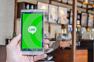 BANGKOK, THAILAND - April 18, 2017. Line app logo display on screen huawei in male hands on April 18,2017 in Thailand.
