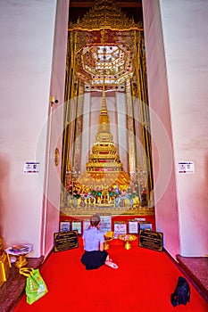 The young lady prays at the Golden Stupain Phra Mondop Shrine of Wat Mahathat temple, on April 23 in Bangkok, Thailand