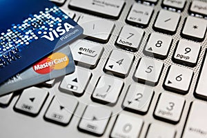 Bangkok, Thailand - August 24, 2017: Close up shot of 2 credit cards VISA and Mastercard on laptop computer with enter button focu