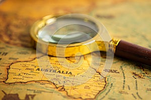Bangkok, Thailand January 20, 2022 Australia, Magnifying glass close up with vintage old antique world map, travel, geography,
