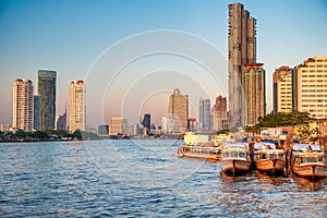 Bangkok, Thailand - January 5, 2020: Chao Phraya River and city skyscrapers from Asiatique Waterfront at sunset