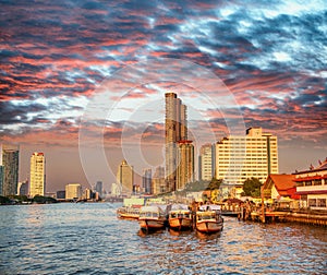 Bangkok, Thailand - January 5, 2020: Chao Phraya River and city skyscrapers from Asiatique Waterfront at sunset