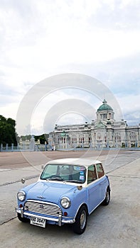 Two tone of blue and white Classic Mini Austin parked on street with ancient castle and sky background