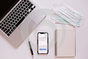 BANGKOK, Thailand - March 28, 2020 : Flat lay of workspace desk with smartphone showing zoom application with mask and covid-19