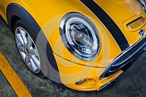 Close-up of Headlights, Wheel, and Rim of Yellow mini cooper