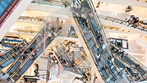 Bangkok, Thailand - Oct 23, 2019: Top view motion blurred of crowded Asian people using escalators in modern shopping mall