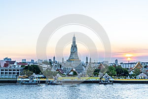 In Bangkok with Wat Arun temple and Chao Phraya River at sunset time,