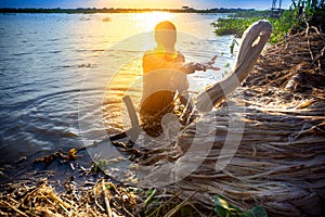 A worker cleans decomposing jute-fibers on the river water in the evening time at Rajrajeshor,