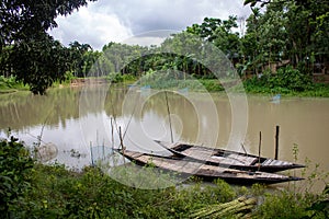 Bangladesh is a riverine country. A quiet beautiful small river. There are two boats tied up at the wharf