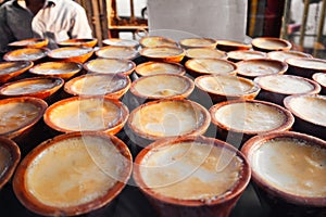 Bangladesh street food. Sweet Mishti Doi in ceramic clay pot photo